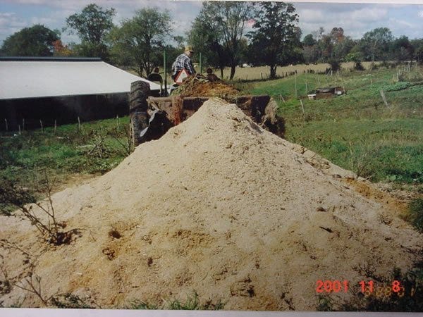Cover the animals with 2 feet of top cover. This cover can be green sawdust, compost material from another finished pile, or dry silage-bedpack.